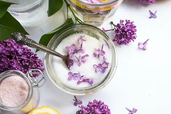 Lilac flowers and lilac sugar in a bowl.