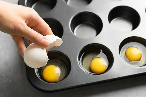 Eggs in a muffin tin demonstrating how to freeze eggs for cooking.